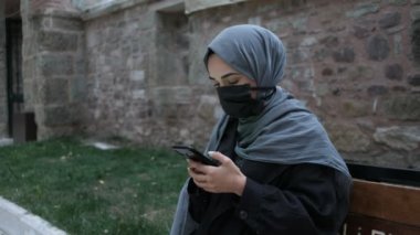 Maskeli Müslüman kadın, yeşil ekran krom anahtar telefon kullanan Müslüman kadın