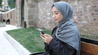 Yeşil ekran krom anahtar, telefonunun yeşil ekranını gösteren Müslüman kadın.