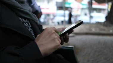 Akıllı telefon kullanan Müslüman kadın 