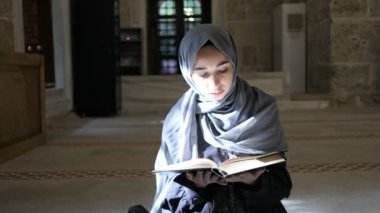 Kuran okuyan genç Müslüman kadın Türk sedir camisinde Kuran okuyor.