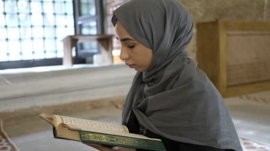 Hijab 'lı genç kadın Kuran okuyor. Tarihi Osmanlı Camii' nde barışçıl Müslüman kız.