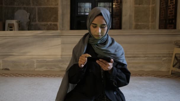 Chica musulmana leyendo quran con teléfono móvil en masjid — Vídeos de Stock