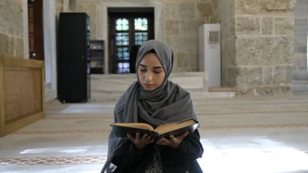 Young Peaceful Muslim, young believer girl reading quran with stone background — Stock Video