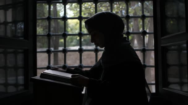 Χιτζάμπ γυναίκα σιλουέτα, μουσουλμάνα γυναίκα σιλουέτα ανάγνωση quran στο ισλαμικό τζαμί — Αρχείο Βίντεο