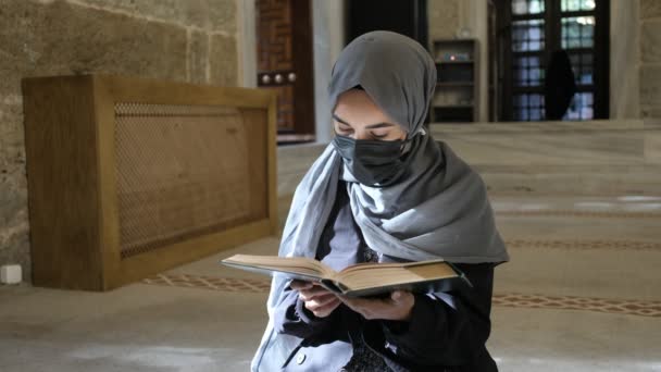Νεαρή μουσουλμάνα γυναίκα, μασκοφόρος μουσουλμάνα γυναίκα που διαβάζει Κοράνι στο τέμενος antic ottoman — Αρχείο Βίντεο