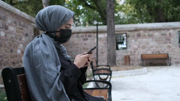 Junge Muslimin mit Maske, Muslimin telefoniert in sozialen Medien