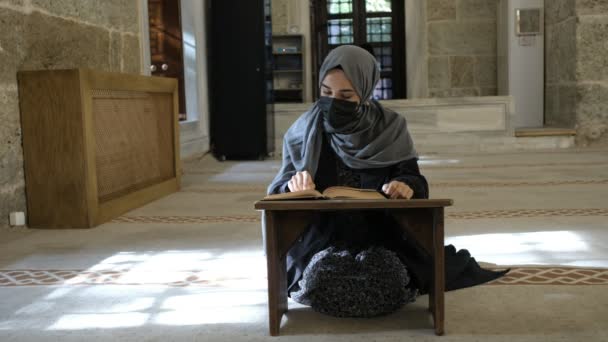 ผู้หญิงฮิญาบมุสลิม ผู้หญิงมุสลิมสวมหน้ากากอ่านคําถาม — วีดีโอสต็อก