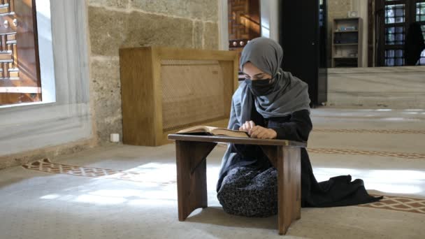 神への崇拝、イスラム教の聖書クルアーンを読むマスタームスリム女性 — ストック動画
