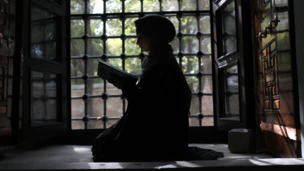 Donna musulmana silhouette, donna musulmana silhouette lettura Corano — Video Stock