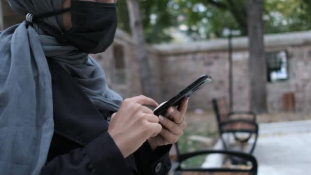 若いヒジャーブ人女性マスクイスラム教徒の女性携帯電話を使って — ストック動画