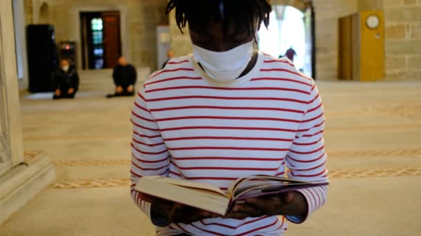Afrikansk man Läsa Koranen, Svart man mask läsa Koranen — Stockvideo