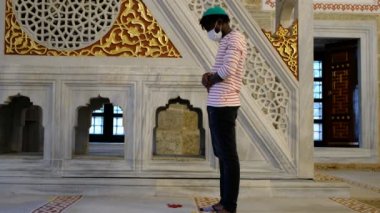 Afrikalı adam maskesi, siyahi genç adam, dua eden cami maskesi.