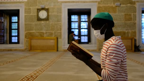 Leitura Alcorão, Africano jovem máscara lendo Corão — Vídeo de Stock