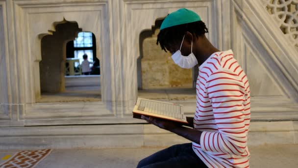Kara Adam Maskesi Kuran, siyah genç adam maskesi Kur 'an okuyor — Stok video