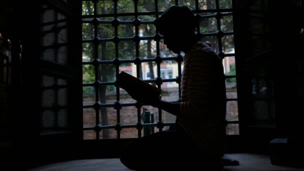 Koraanin lukeminen, Mies siluetti lukeminen muslimi pyhäkirja — kuvapankkivideo
