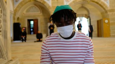 Afrikalı adam duası, siyah adam maskesi dua eden mescit.