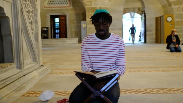 Hombre negro leyendo el Corán, hombre africano leyendo la mezquita Quran — Vídeos de Stock