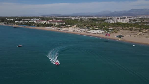 Parasailing vytáhl motorový člun opustí pláž — Stock video