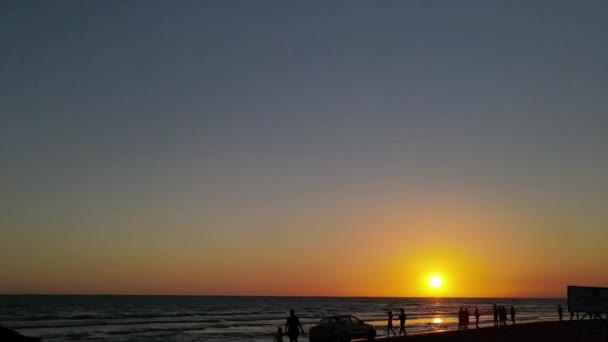 Ηλιοβασίλεμα γρήγορη θέα των ανθρώπων στην παραλία — Αρχείο Βίντεο