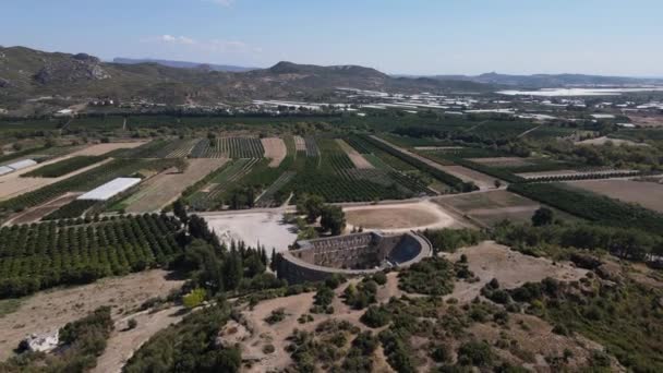 Vista del antiguo teatro a través de tierras de cultivo verdes — Vídeos de Stock