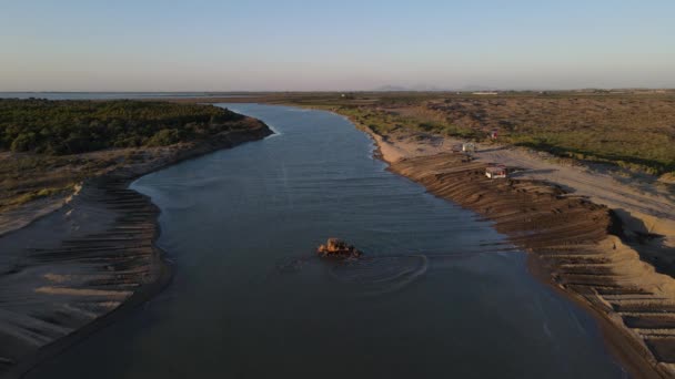 A buldózer homokot szállít a partra a vízen keresztül. — Stock videók