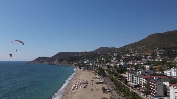 Drone vista dei parapendio che scendono verso la spiaggia — Video Stock