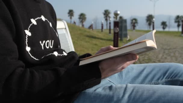 Czytając książkę na ławce — Wideo stockowe