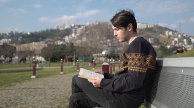 Genç adam kitap okuyor.