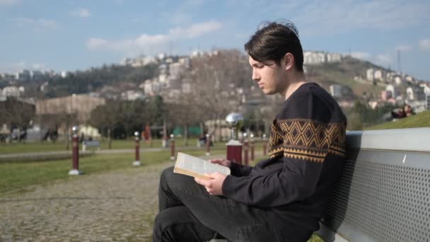 Genç adam kitap okuyor. — Stok video