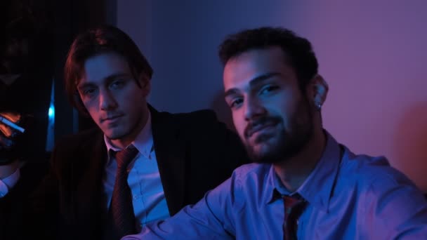 Dwóch mężczyzn uśmiecha się na fioletowym tle — Wideo stockowe