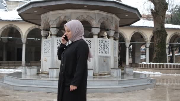 Telefoongesprek in moskee binnenplaats — Stockvideo