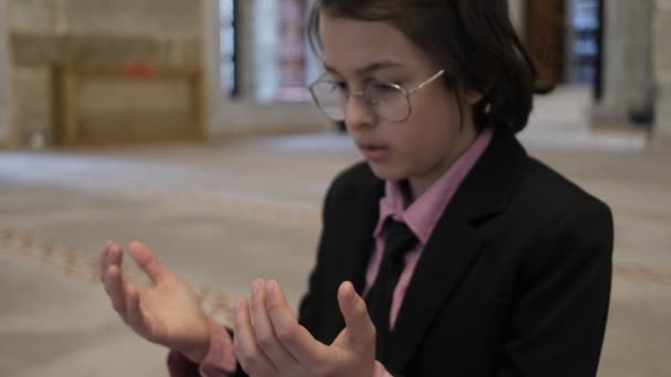 Маленький мальчик молится в мечети — стоковое видео