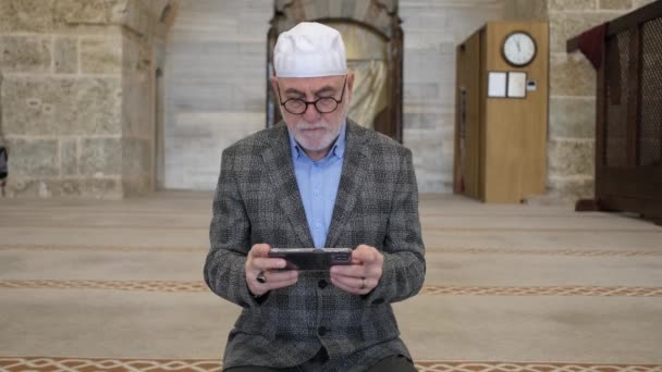 Vecchio che legge il Corano al telefono — Video Stock