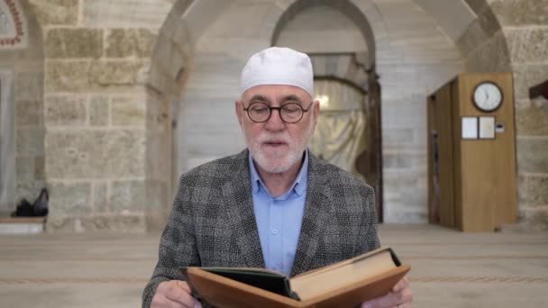 Het bidden van de koran op de houder — Stockvideo