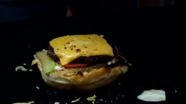 Katmanlı çedar peynirli zengin hamburger resmi, yavaş çekimde hamburger, kızarmış köfte ve çedar peyniri ile hamburger menüsü.