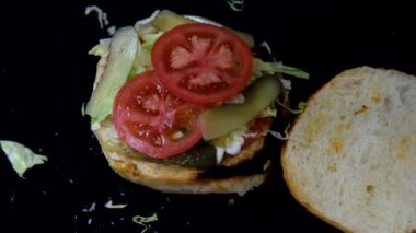 Katmanlı hamburgerin yavaş çekimi, domates peynirli hamburger menüsü görüntüsü, lezzetli hamburgerler, izole edilmiş fast food yemeği görüntüsü.