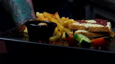 Kahvaltı servisi tabağı, tost ve patates kızartmasının ayrı promosyon görüntüsü, kahvaltılık atıştırmalıkların yavaş çekim sunumu.