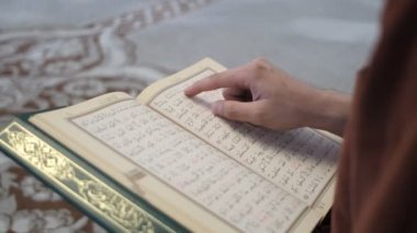 Açık Kur 'an' ı takip eden ve parmaklarıyla okuyan, Arapça Alfabeyle Kur 'an okuyan, İslam' a ait kutsal Kur 'an' ı okuyan.