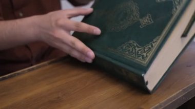 Kur 'an' ı ahşap kürsüde açıp Kuran 'ın cümlelerini yakından okumaya başlamak, Arap alfabesinin İslam kutsal kitabı