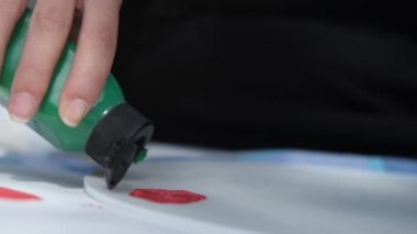 Boya paletine boya ekleme görüntüsü palete yağ boyasının eklenmesi, renkleri fırçayla karıştırma görüntüsü