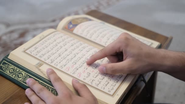 在木制讲台上阅读 古兰经 用阿拉伯文字阅读伊斯兰圣书 近距离阅读 古兰经 用手指学习阅读 古兰经 — 图库视频影像