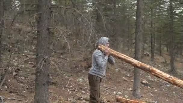 후드를 젊은이가 나무로 통나무를 가지고 스포츠를 통나무로 자연스럽게 운동하는 — 비디오