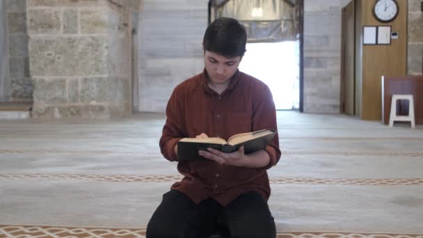 穆斯林少年背诵他手里拿着的奎兰 一个男人在清真寺里从奎兰祈祷的图像 尊重奎兰 — 图库视频影像