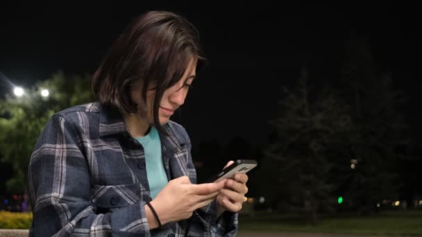 Les Images Fille Assise Seule Dans Parc Regardant Son Téléphone — Video