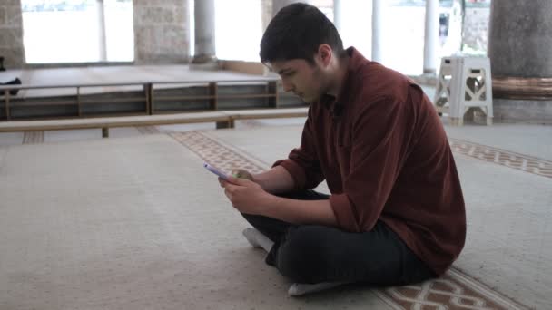 Man Zit Zijn Knieën Moskee Kijken Naar Zijn Telefoon Met — Stockvideo