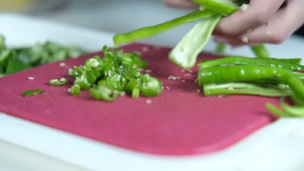 粉红切菜板上的绿色辣椒 菜刀上的绿色辣椒 厨房准备食物的图像 — 图库视频影像