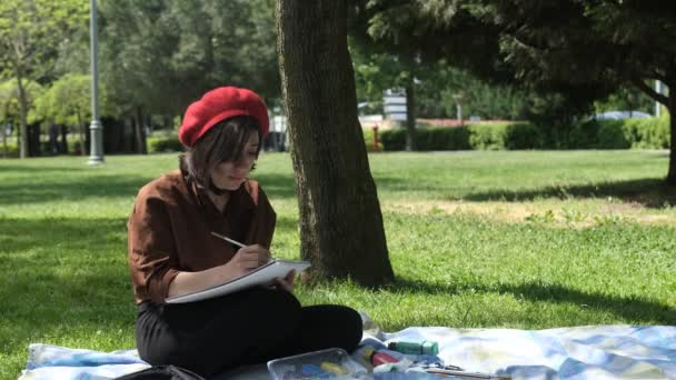 Γυναίκα Καλλιτέχνης Κάθεται Και Ζωγραφική Ανάμεσα Πλούσια Δέντρα Σχέδιο Πινέλο — Αρχείο Βίντεο