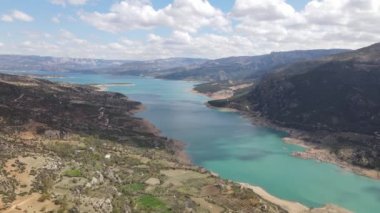 Drone view of the dam in the middle of the land surrounded by high mountains, view of artificial irrigation dam in turkey