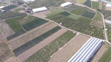 Geniş ovalardaki yeşil alanlar, farklı renklerde ekilmiş arazilerin drone görüntüsü, kırsal alanların havadan görünüşü, seraların ve tarım arazilerinin drone görüntüleri.
