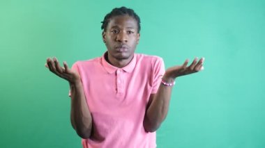 How should i know body language of black man making signs, the sign representing of i have no idea, image of emotions and facial expressions taken in front of the green curtain